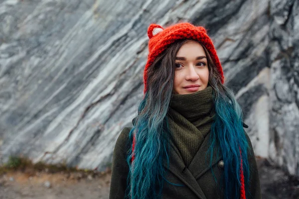 Portrait of a beautiful hipster girl on the background  the rocky cliffs. Dyed hair, blue, long. — Stock Photo, Image