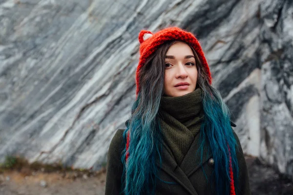 Portrait of a beautiful hipster girl on the background  the rocky cliffs. Dyed hair, blue, long. — Stock Photo, Image