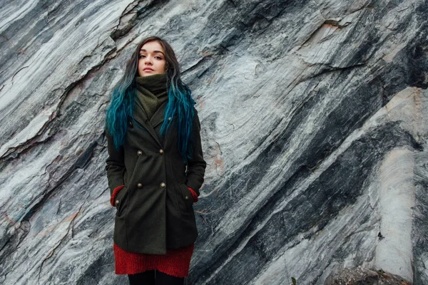 Retrato de una hermosa chica hipster en el fondo los acantilados rocosos. Pelo teñido, azul, largo . — Foto de Stock