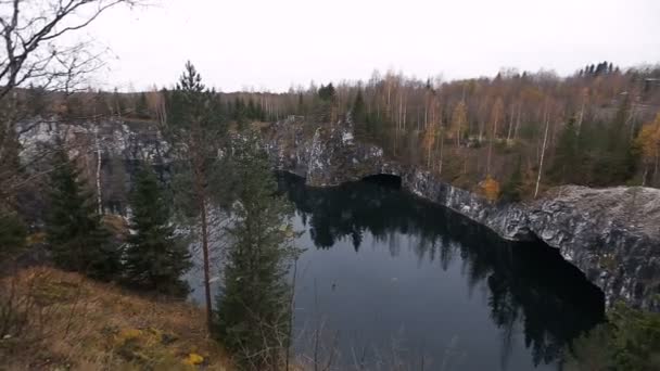 Lovely view of the lake with emerald hill, surrounded by cliffs. Nobody here. Forest reflection in water. — Stock Video