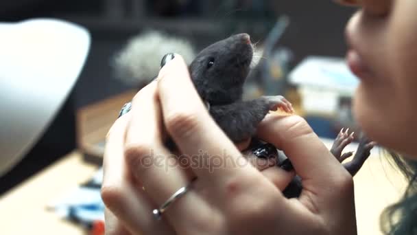 Mooi lief meisje houdt een hand een klein huisdier thuis weinig bruin muis close-up. Ze aaien haar kussen en glimlacht. Jonge vrouw met pet rat. — Stockvideo