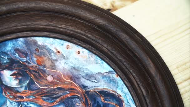 Aquarellmalerei in einem runden Holzrahmen auf einem Regal. grüne Pflanzen im Hintergrund. Bohemia Studio. Surrealismus Fantasiemalerei. niemand — Stockvideo
