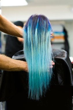 Boyalı saçlı güzellik salonu stüdyoda bir sandalyede oturan bir kız. Gösteri üzerinde çalışmak.