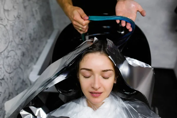 Menina lavar a cabeça em um salão de beleza. Coloração do cabelo, folha metálica — Fotografia de Stock