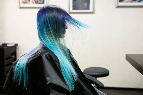 A girl with dyed hair sitting in a chair at the beauty salon studio. Work over the demonstration — Stock Photo, Image