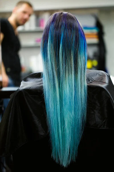 Een meisje met geverfd haar, zittend in een stoel in de schoonheidssalon studio. Werken over de demonstratie. — Stockfoto