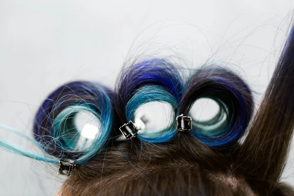 Headshot of a young woman with hair curlers in a beauty salon. — Stock Photo, Image