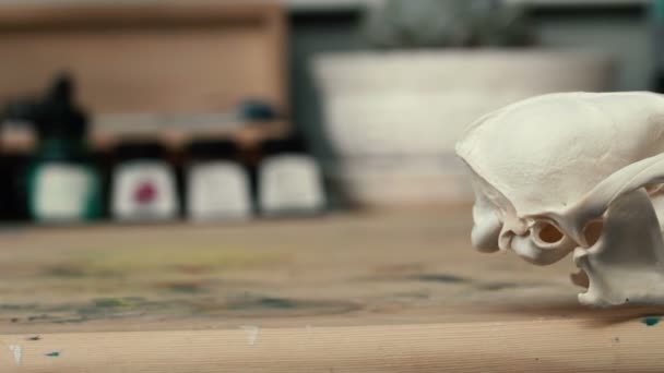 Renard crâne couché sur une table en bois. Teintes de peinture colorée acrylique et aquarelle, artiste de lieu de travail .