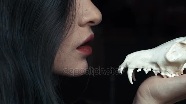 Tajemniczą młodą czarownicę szepcze przekleństwo i zaklęcie gospodarstwa czaszki w ręce Lisa. — Wideo stockowe