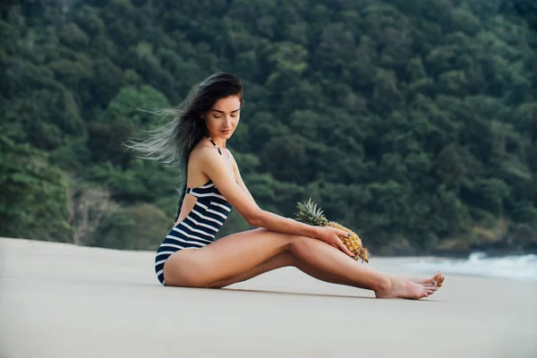 Mulher bonita relaxante em uma praia com abacaxi . — Fotografia de Stock