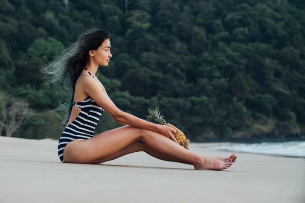 Mulher bonita relaxante em uma praia com abacaxi . — Fotografia de Stock