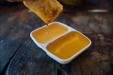 Beyaz bir sauceboat iki bölümlerden sıvı bal. Ahşap bir masaya