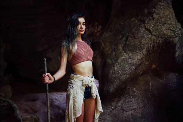 Jovencita en el fondo de una vieja cueva. El concepto de armonía con la naturaleza  . — Foto de Stock