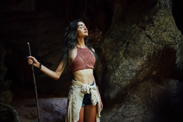 Jovencita en el fondo de una vieja cueva. El concepto de armonía con la naturaleza  . — Foto de Stock