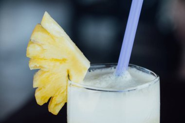 Ananas suyu bir bardak, meyve ve bir tüp.