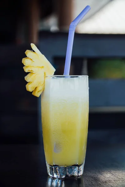 Suco de abacaxi em um copo, parte de fruto e um tubo . — Fotografia de Stock