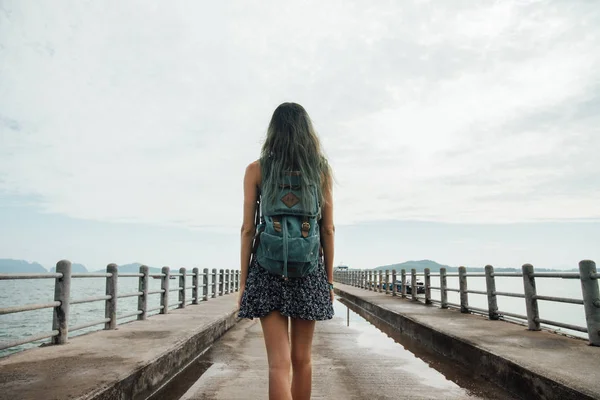 Girl in the dress is walking on the pier. Back view. Dyed hair — Stock Photo, Image