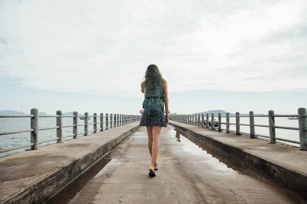 La chica del vestido está caminando por el muelle. Vista trasera. Cabello teñido — Foto de Stock