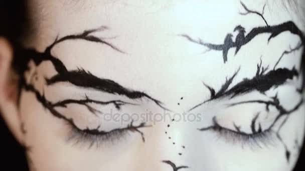 Μόδα close-up πορτρέτο του γυναικείο μοντέλο με ένα εκπληκτικά δημιουργική make-up. Ζωγραφισμένα muah σιλουέτες. — Αρχείο Βίντεο