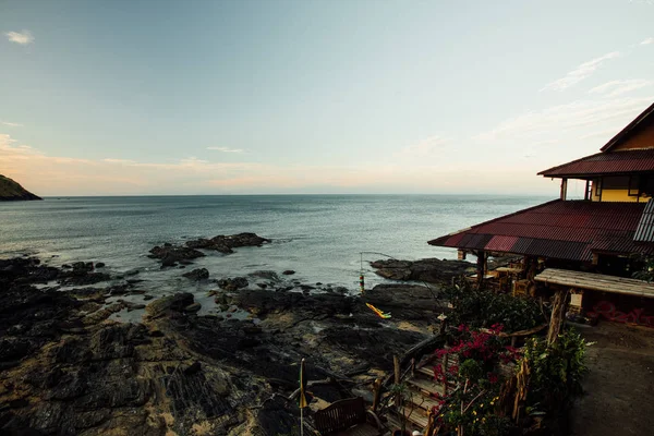 Ασιατικές μπανγκαλόου έναντι μιας ήρεμης θάλασσας. Βραχώδης θαλάσσια ακτή bungalows τοπίο — Φωτογραφία Αρχείου