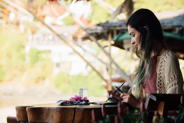 Portrait brunette woman sitting at wooden table and looking into distance — Stock Photo, Image