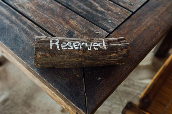 Table with sign reserved on wooden plank. Reservation table in restaurant