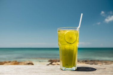 Kokteyl buz cam ve limon ile beach Cafe ahşap masa üzerinde duruyor