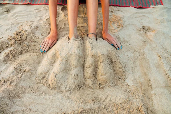 Lábak a gyönyörű fiatal nő temették el, a homokos strandon. Szexi nő ül a homok — Stock Fotó