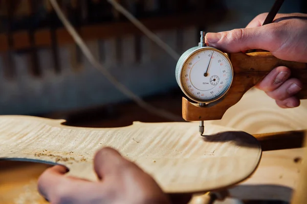 Master artisan instrumentmakare arbetar på skapandet av en fiol. mödosamt detaljerade arbete på trä. — Stockfoto