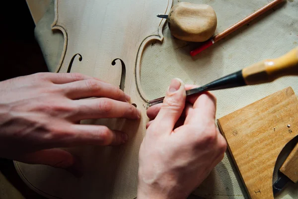 Master artisan luthier working on the creation of a violin. painstaking detailed work on wood. — Stock Photo, Image