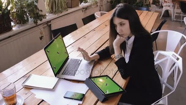 Podnikatelka tabletový počítač pomocí zelené dotykové obrazovky v kavárně na dřevo stůl.