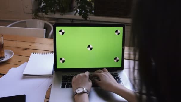 L'azienda femminile sta lavorando al computer con il verde. Su un tavolo di legno ci sono carte e documenti . — Video Stock