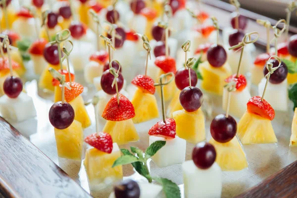 Ensemble de délicieuses canapés avec fraise, ananas, melon et raisin . — Photo