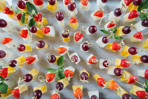 Ensemble de délicieuses canapés avec fraise, ananas, melon et raisin . — Photo