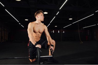 Yakışıklı vücut geliştirmeci adam portresi hazırlamak halter bir spor salonunda egzersiz yapın, halter plaka tutmak için.