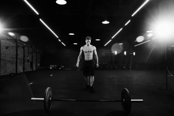 Lekkoatletycznego mężczyzna pompowane kulturysta stoi z przodu bar w siłowni. Fitness mężczyzna gotowy do pracy. — Zdjęcie stockowe