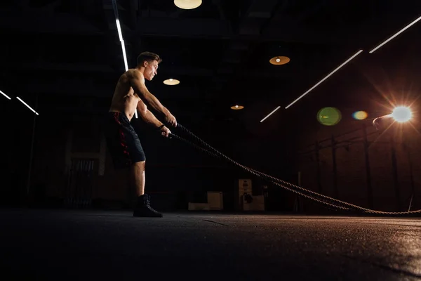 Ejercicio de fitness con cuerdas de batalla en el gimnasio. ejercicio de entrenamiento cuerpo cabido en el club. Torso . — Foto de Stock