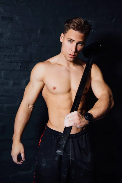 一个年轻的身体健壮的男人锻炼在健身房用锤子的画像。肌肉运动 . — 图库照片