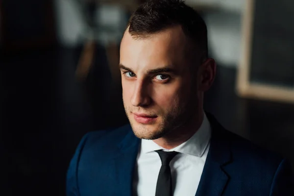 Young attractive and confident businessman in blue suit and black tie. — Stock Photo, Image