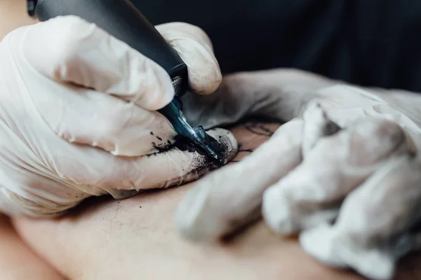 Закрытие процесса рисования на коже черно-белой татуировки и затенение контуров — стоковое фото