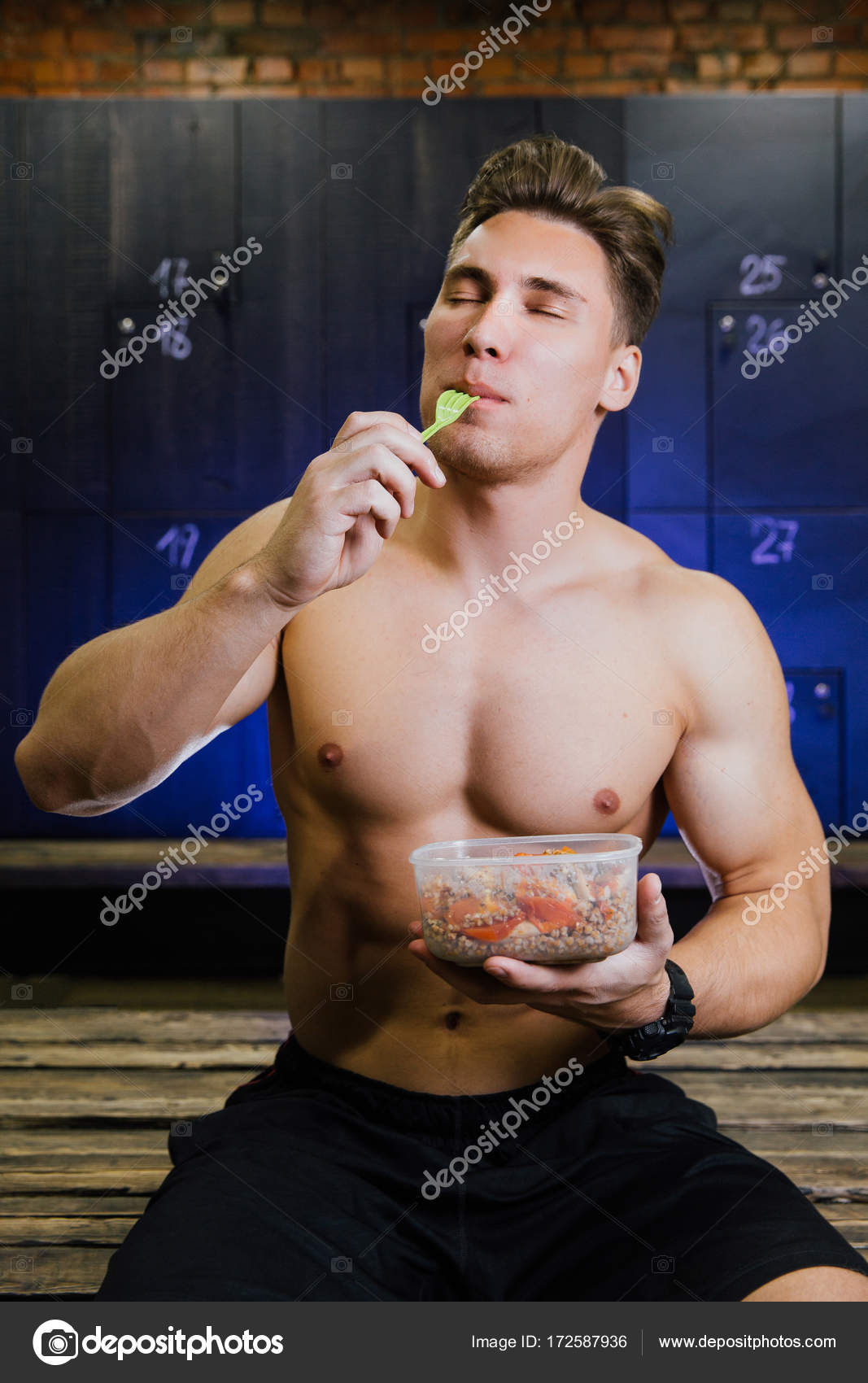 Fitness Model Of A Bodybuilder Guy Eating Food From A