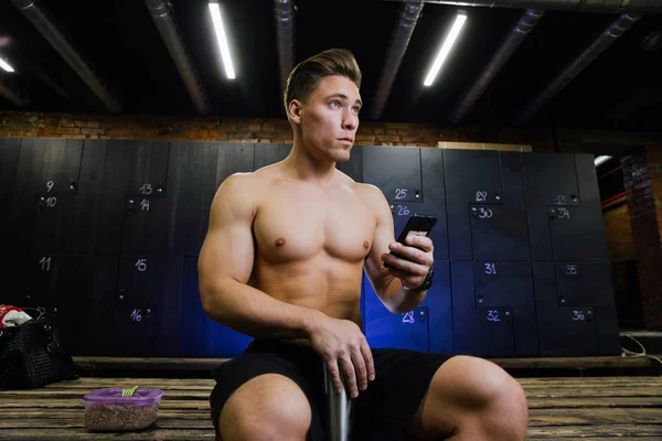 Jeune homme au vestiaire de gym. Beau gars à la salle de fitness faire leur propre personnel avant l'entraînement . — Photo
