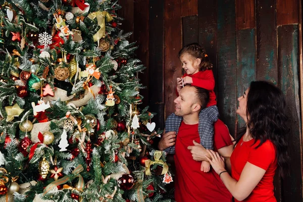 Mutlu bir aile Noel ağacını bayraklarla süslüyor oturma odasında.. — Stok fotoğraf