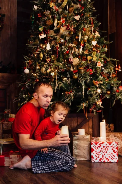 Bir Noel ağacı, mumlar dışarı üfleme baba kızı. — Stok fotoğraf