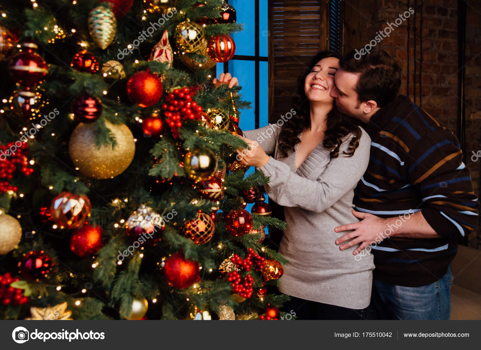 Joven pareja de enamorados decora un árbol de Navidad en casa — Foto de Stock