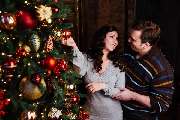 Jeune couple amoureux décore un sapin de Noël à la maison — Photo