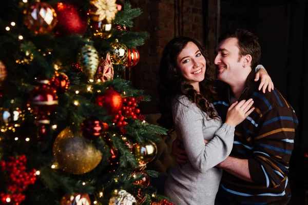 Jovem casal apaixonado decora uma árvore de Natal em casa — Fotografia de Stock
