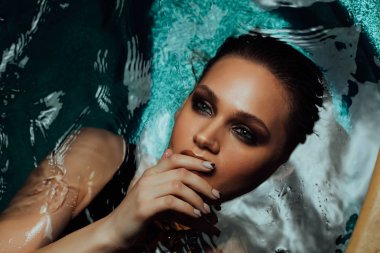 Güzel seksi kadın portresi su havuzu yer almaktadır. Cinsel dudaklar parmak dokunmatik.