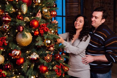 Aşık genç çift evde bir Noel ağacı süsle