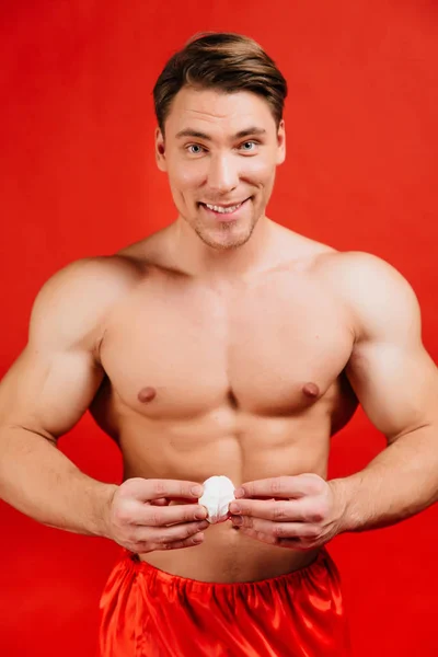 Vánoce, nový rok svátky a zdravých potravin. Sexy Fit Santa muže jíst marshmallows krém. — Stock fotografie